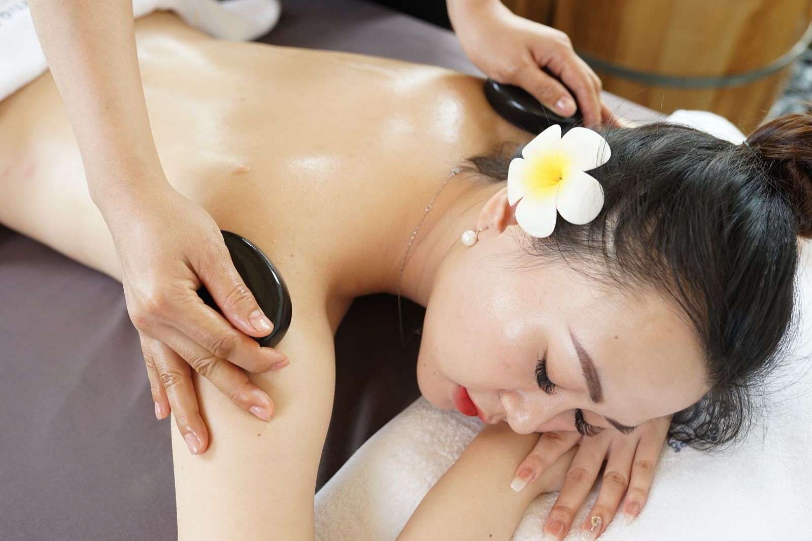Massage bằng đá nóng tại trung tâm trị liệu, spa hoặc tại nhà